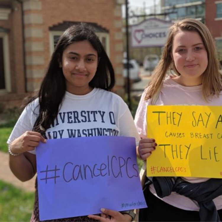 Two student advocates holding signs in protest