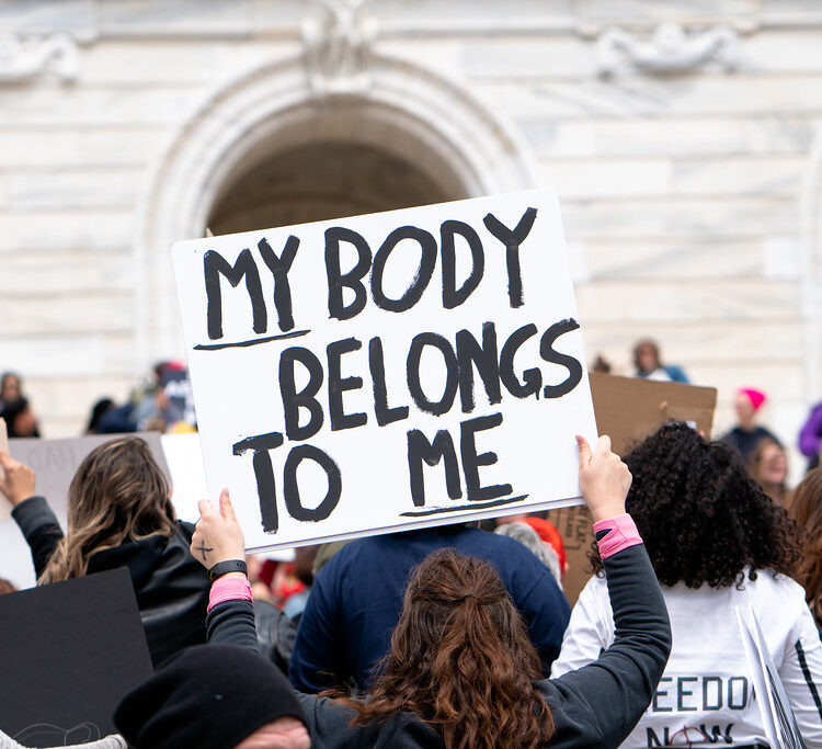 person holding a sign that says &quot;my body belongs to me&quot;